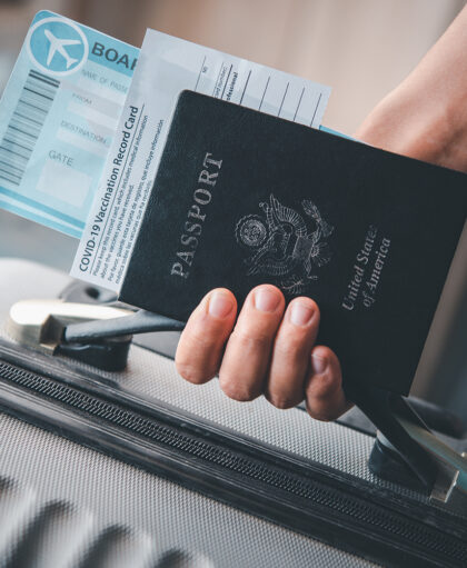 People holding passports and Coronavirus vaccination record card, map for travel with luggage for the trip. Covid-19 around the world