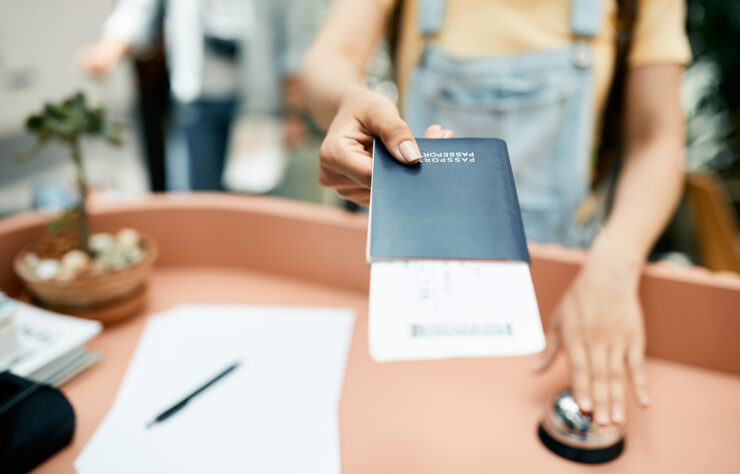 Close-up of woman giving her passport during hotel check-in.